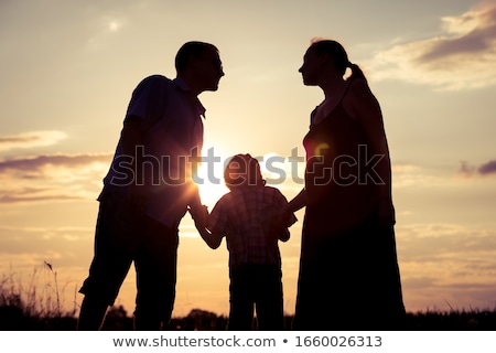Stock foto: Happy Family Standing In The Park At The Sunset Time