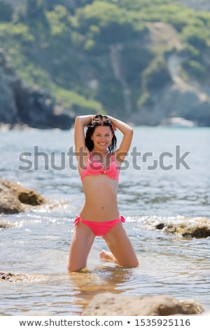 Stock fotó: Woman In Bikini Kneeling On Rock