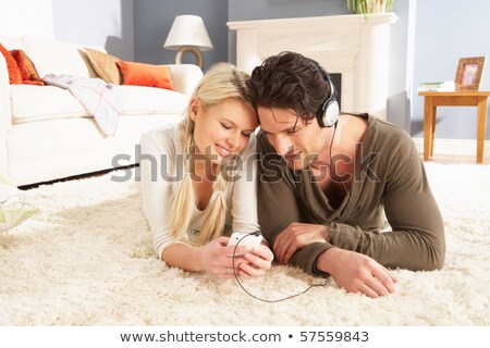 Stockfoto: Couple Listening To Mp3 Player On Headphones Relaxing Laying On