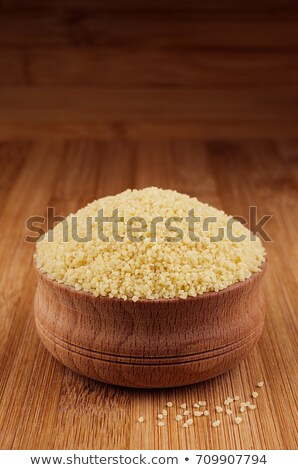 Stockfoto: Couscous In Wooden Bowl On Brown Bamboo Board Closeup Healthy Dietary Groats Background