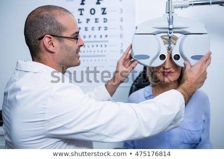 Foto stock: Optometrist Examining Female Patient With Phoropter