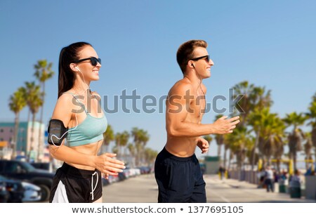 Stock fotó: Couple With Earphones Running Over Venice Beach