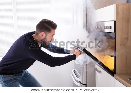 Stock fotó: Man Looking At Fire Coming Out From Oven