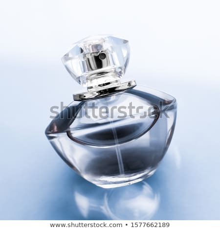 Stock foto: Blue Perfume Bottle On Glossy Background Sweet Floral Scent Gl