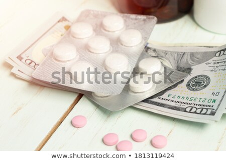 Stok fotoğraf: Medicine Pills Stacked On Newly Designed One Hundred Dollar Bill