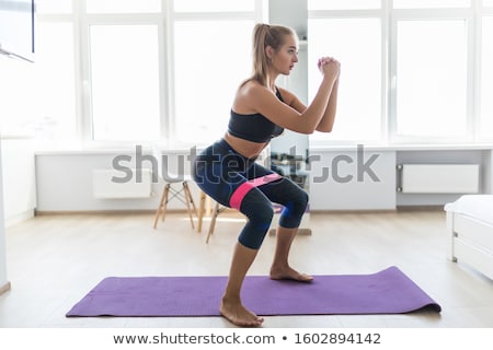 Stockfoto: Woman Stretching Her Leg On Exercise Mat