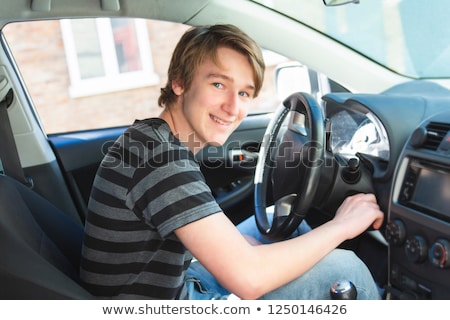 Stok fotoğraf: A Teenage Boy And New Driver Behind Wheel Of His Car