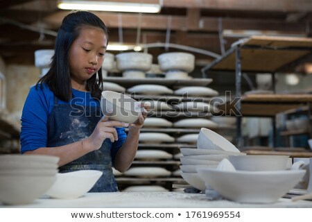 Stock photo: Attentive Girl Checking Bowl At Worktop