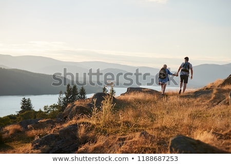 Foto stock: A Couple Holding Hands By A Lake