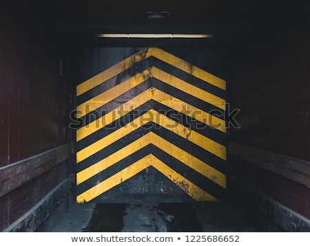 Stockfoto: A Yellow Arrow On Old Concrete Road