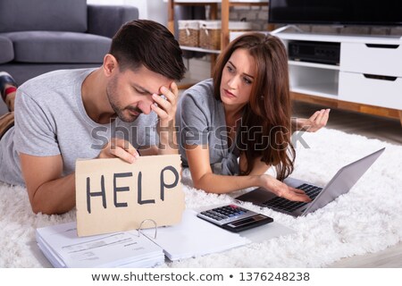 Foto d'archivio: Couple Holding Help Sign While Calculating Invoice