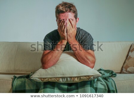 Stok fotoğraf: Thinking Man With Face Covered Sitting On Couch