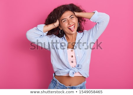 ストックフォト: Young Woman Sticking Toungue Out At Camera