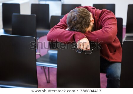 Foto stock: Exhausted Boy Holding Glasses And Sleeping In Meeting Room