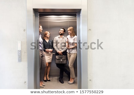 Сток-фото: Businessman And Businesswoman Standing In An Elevator