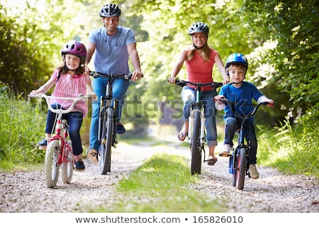 Stockfoto: Happy Family Is Riding Bikes Outdoors And Smiling Father On A Bike And Son On A Balancebike