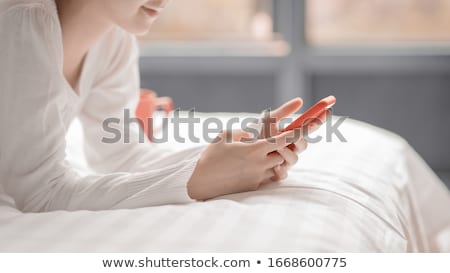 Zdjęcia stock: Young Woman Using A Smartphone In Bed