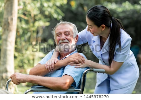 Сток-фото: Senior Man Sitting On Wheelchair With Female Nurse