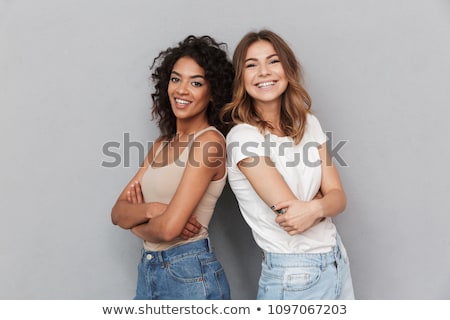 Zdjęcia stock: Two Smiling Women Posing Together And Looking At The Camera
