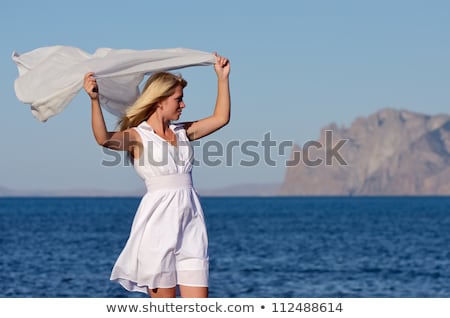 Foto stock: Happy Woman With Shawl Waving In Wind On Beach