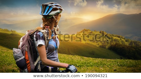 Stock foto: Woman Cyclist On A Mountain Bike Looking At The Landscape Of Mou