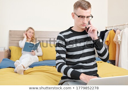 Stok fotoğraf: Young Woman Is Working On A Laptop In His Bed On A Background Of A Panoramic Window Overlooking The