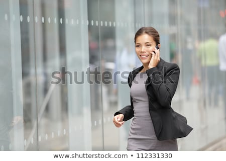 Image Of Young Asian Woman Talking On Cellphone While Working In Foto stock © Maridav