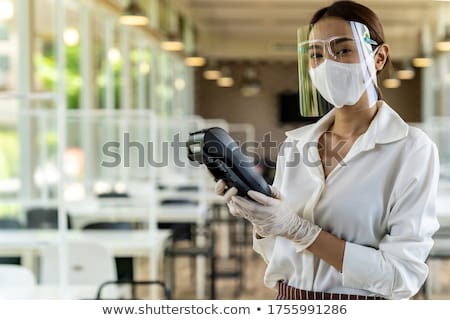Foto stock: Waitress With Face Mask Hold Credit Card Reader