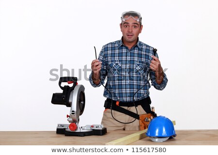 Foto stock: Craftsman Holding The Cable Of His Broken Electric Cutter