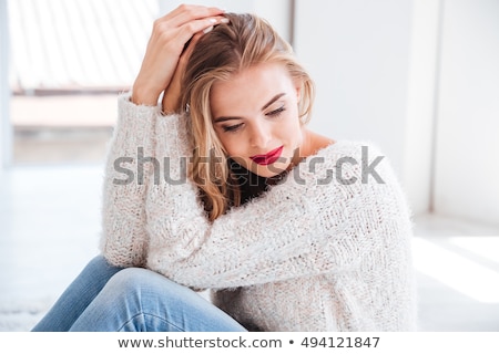 Foto stock: Girl Wearing Sweater And Red Lipstick Sitting On The Carpet