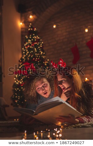 Foto stock: Man Lying With Friends Looking At Photo Album