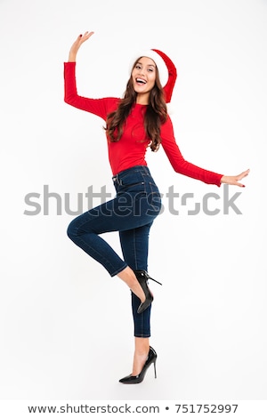 Stockfoto: Full Length Of A Cheerful Young Girl Wearing Red Santa Hat