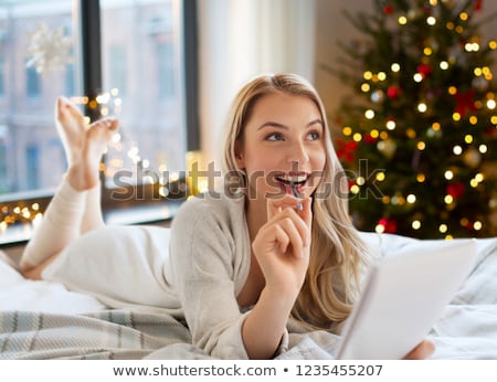 Stockfoto: Smiling Girl Writing Christmas Wish List At Home