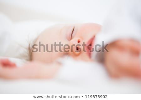 Stock photo: Baby Falling Asleep While Extending Her Arms In A Bedroom