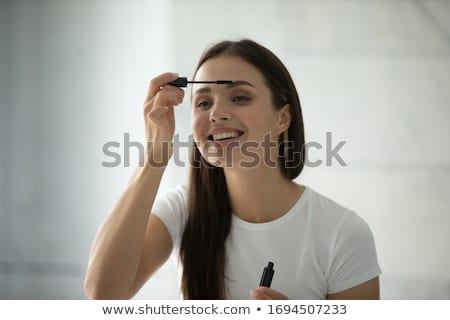 Foto d'archivio: Young Woman Applying Mascara