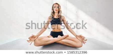 Stockfoto: Young Woman Practices Yoga And Meditates In The Lotus Position I