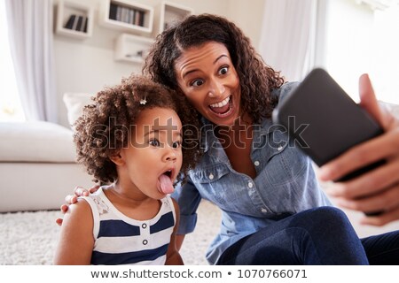 Stockfoto: Front View Of African American Happy Girl Taking A Selfie Of Her Family At The Dinning Table With H