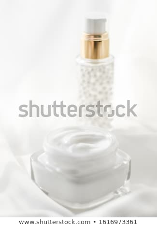 Foto d'archivio: Face Cream Moisturizer Jar And Serum Gel On White Silk Skin Car