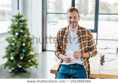 Stockfoto: Man Drinking Coffee Near Decorated Christmas Tree In Winter Forest