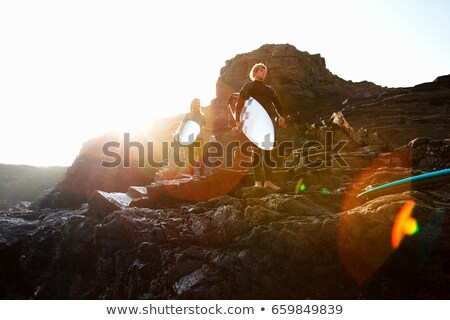 Zdjęcia stock: Couple Standing On Large Rocks With Surfboards