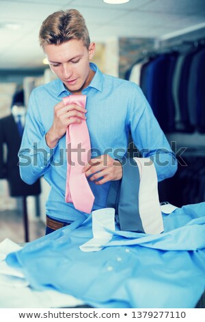 Imagine de stoc: Adult Man Choosing Shirt In Clothes Shop