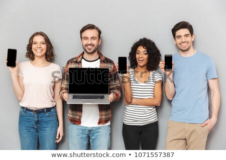 Stockfoto: Happy Group Of Friends Showing Displays Of Mobile Phones And Laptop Computer