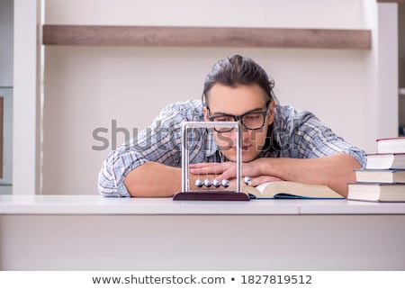 [[stock_photo]]: Young Student Physicist Preparing For Exam At Home