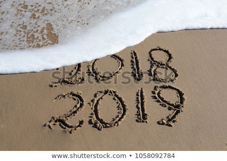 Сток-фото: New Year 2019 Is Coming Concept - Inscription 2018 And 2019 On A Beach Sand The Wave Is Almost Cove