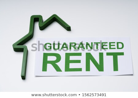 Сток-фото: Green House Model And Paper With Guaranteed Rent Text