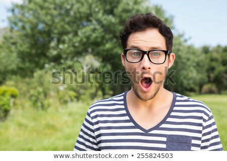 Foto stock: Handsome Hipster Looking Surprised In Park