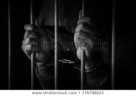 Stock photo: Handcuffed Man Behind Prison Bars