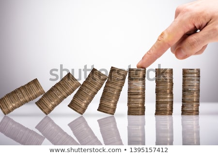 Stok fotoğraf: Businessperson Protecting Stacked Coins From Falling On Desk