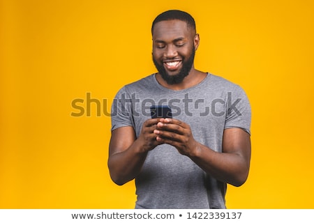 Foto stock: Young Man Holding His Cellphone Against A White Background