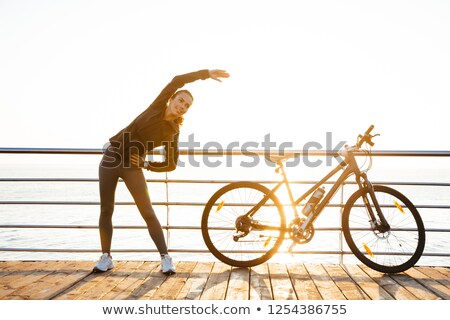 Stok fotoğraf: Image Of Attractive Woman Standing With Bicycle On Boardwalk Du